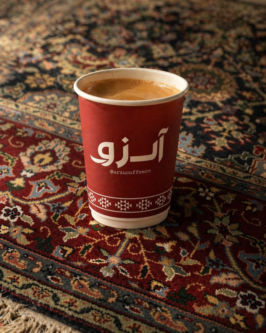 An Arzu Coffee Co. cup of espresso resting on a hand-knotted Persian rug